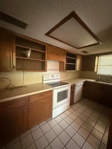 a kitchen with stainless steel appliances a sink stove and cabinets