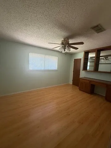 a view of an empty room with a chandelier fan