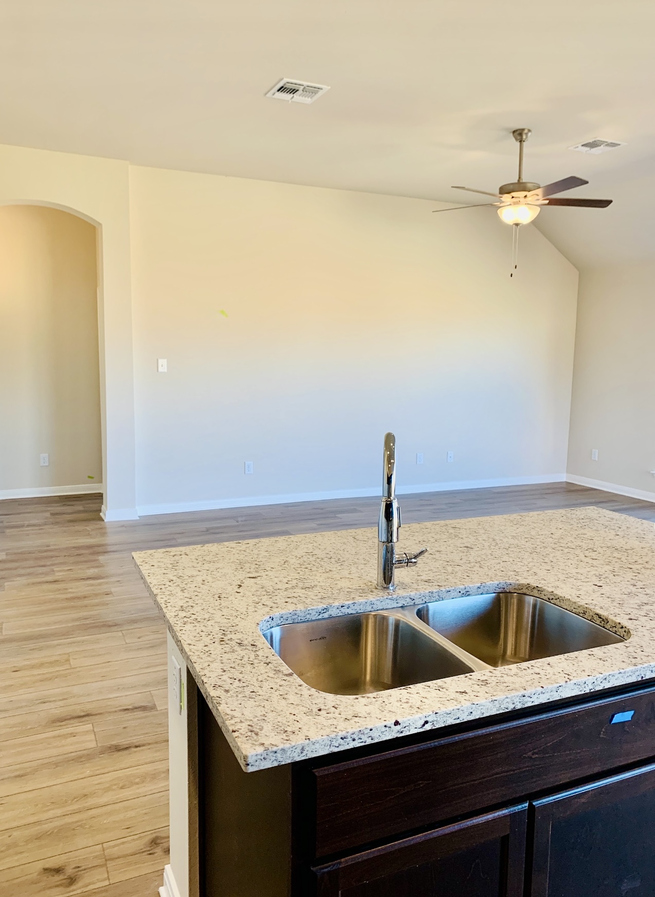 808 Fallbrook Drive Temple, TX 76502 - Photo 36 of 36 Kitchen with light wood finished floors, a ceiling fan, light stone counters, arched walkways, and open floor plan