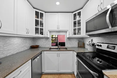 a kitchen with stainless steel appliances granite countertop a stove and a microwave