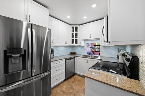 a kitchen with a refrigerator sink and cabinets