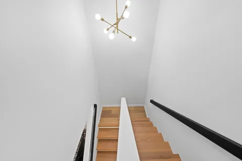 a view of a hallway with wooden floor and a carpet
