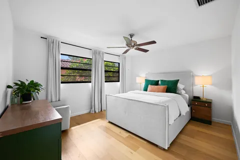 a bedroom with a large bed and a potted plant