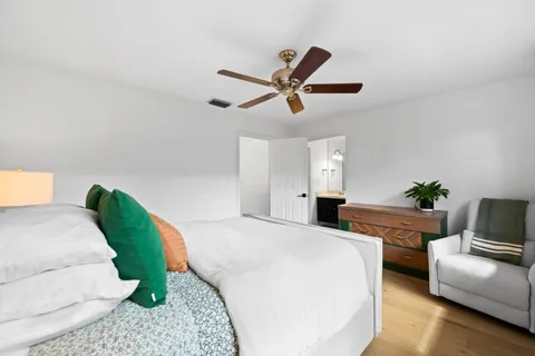 a bedroom with a bed a couch and a chandelier