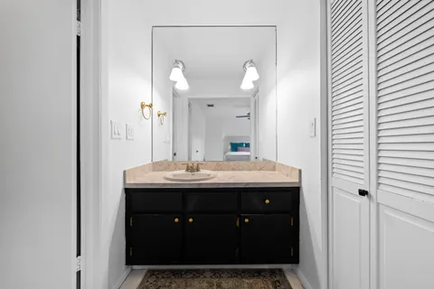 a bathroom with a granite countertop sink and a mirror