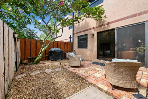 a backyard of a house with barbeque oven table and chairs