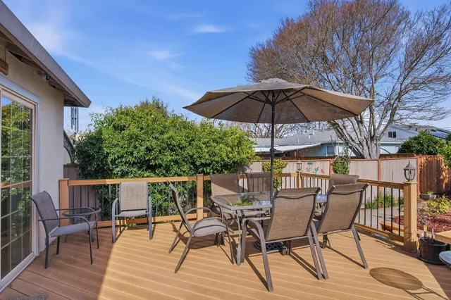 a view of a chairs and table in the patio with a barbeque grill