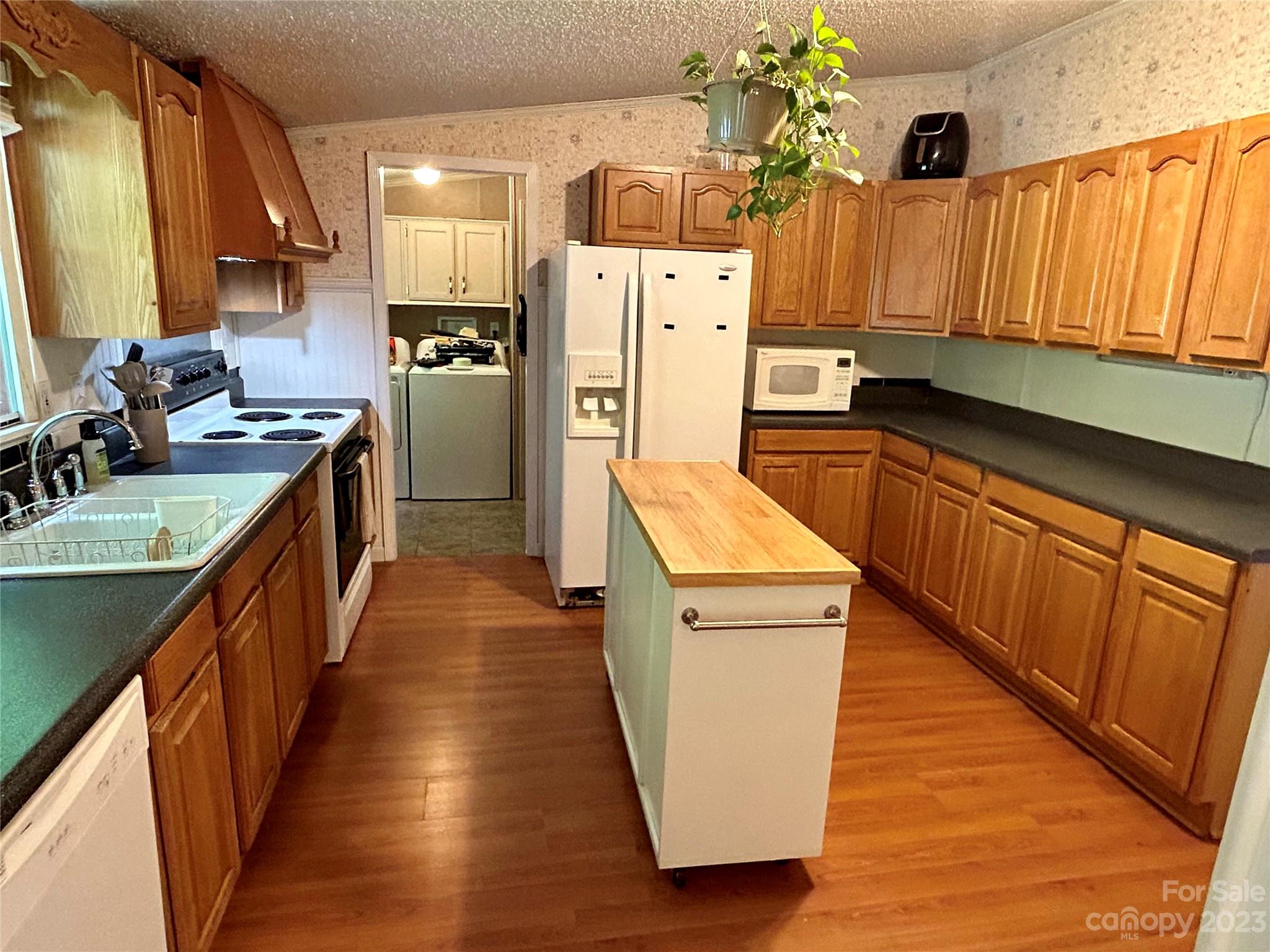 71 Bear Trail Fairview, NC 28730 - Photo 14 of 42 a kitchen with wooden cabinets a sink dishwasher and a refrigerator
