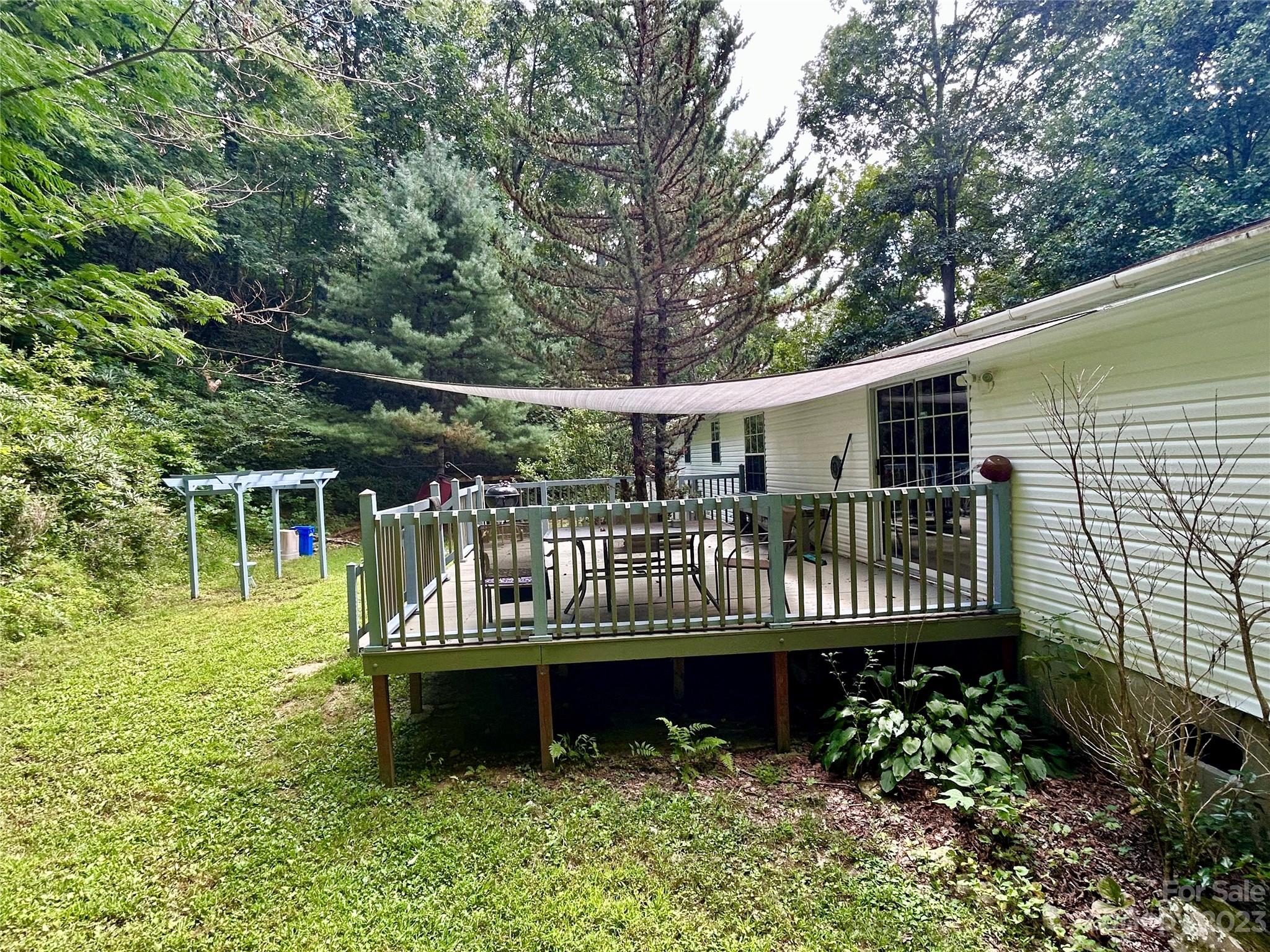 71 Bear Trail Fairview, NC 28730 - Photo 38 of 42 a view of a house with a wooden deck and a yard