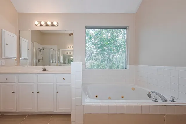a bathroom with a bathtub a sink and a window