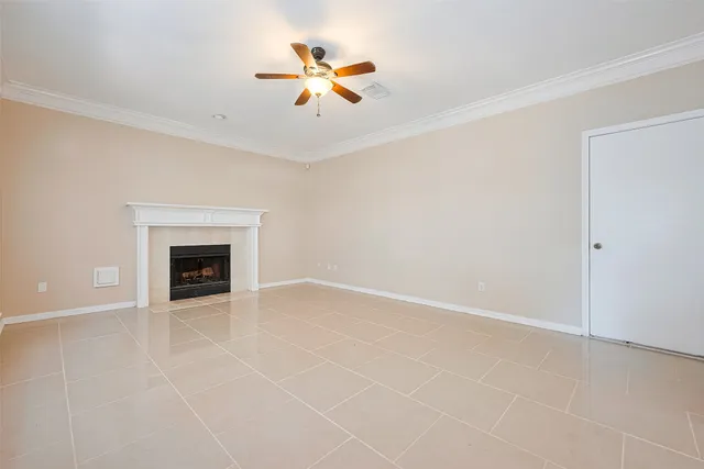 an empty room with ceiling fan and window