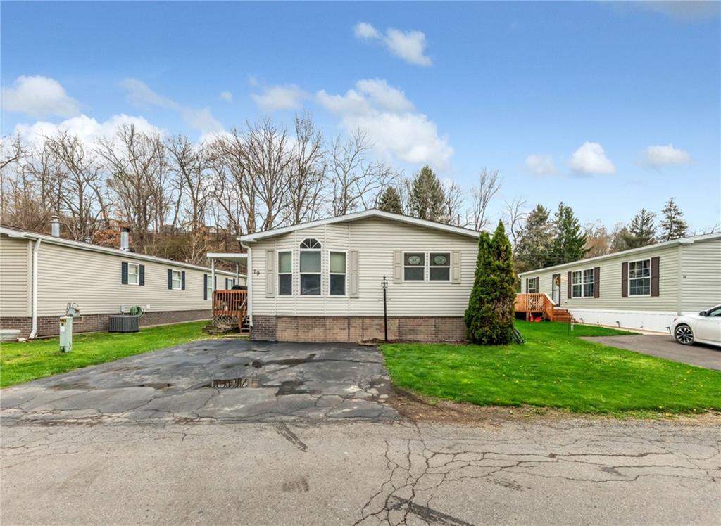 a view of a yard in front of a house with a patio