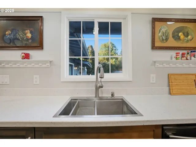 a kitchen with kitchen island a counter top space a sink stainless steel appliances and cabinets
