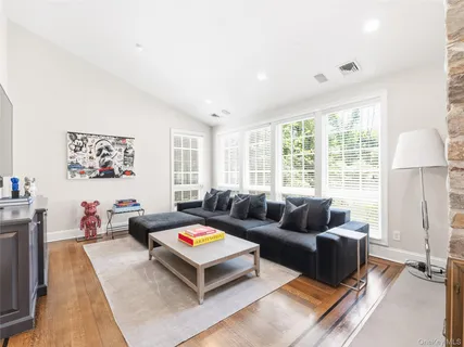 a living room with furniture a rug and a large window
