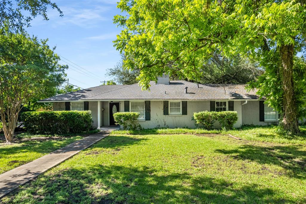 Ranch-style house featuring a front lawn, a chimney, and brick siding