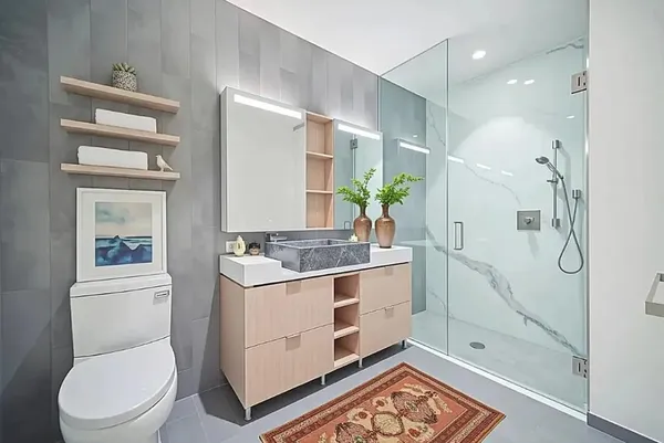 a bathroom with a granite countertop sink a toilet and shower