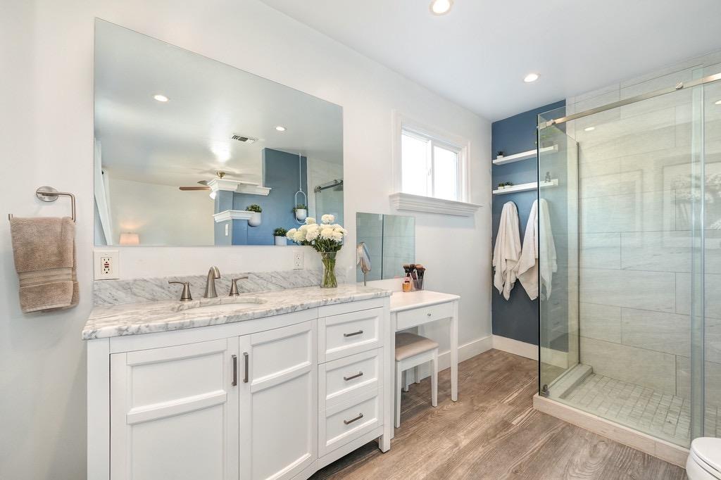 a spacious bathroom with a granite countertop sink mirror and shower