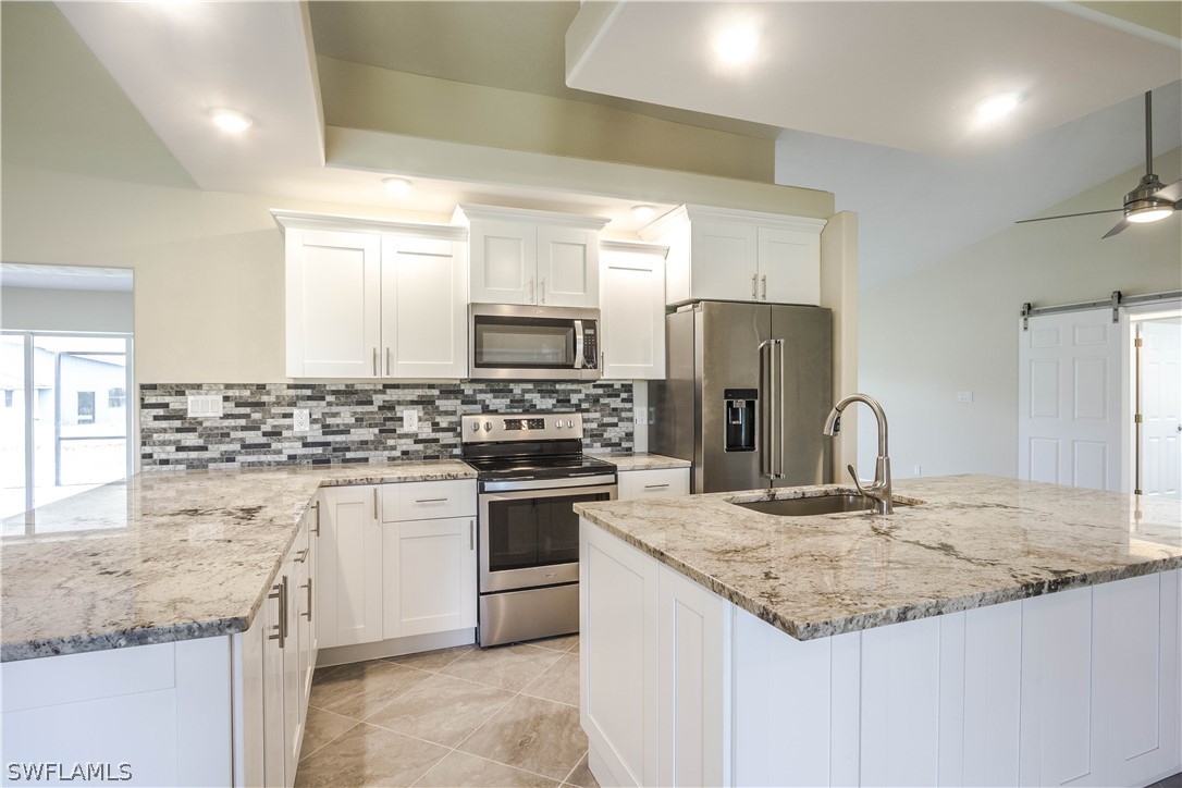 2871 Styles Road Alva, FL 33920 - Photo 8 of 33 a kitchen with granite countertop a sink stove and refrigerator