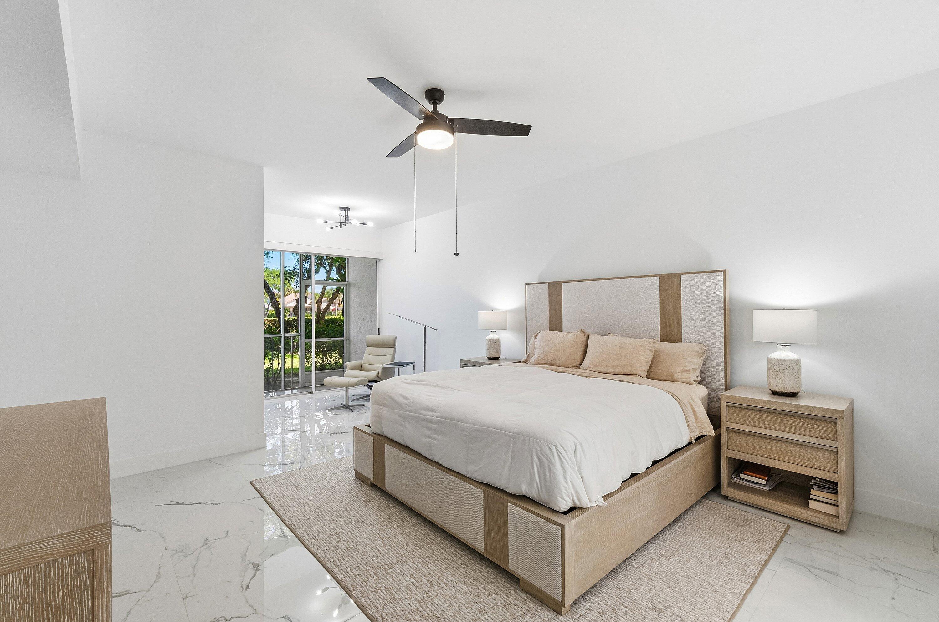 5082 Lake Catalina Drive, Unit A Boca Raton, FL 33496 - Photo 11 of 35 a bedroom with a bed and a chandelier