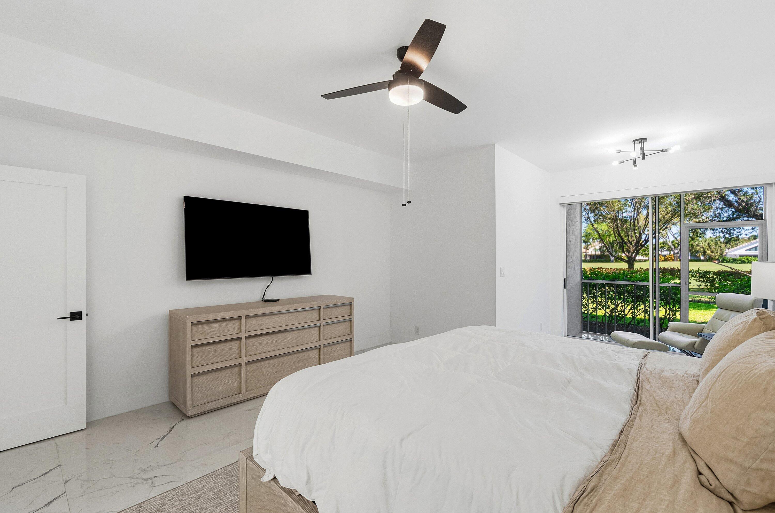5082 Lake Catalina Drive, Unit A Boca Raton, FL 33496 - Photo 12 of 35 a bedroom with a bed and a flat screen tv