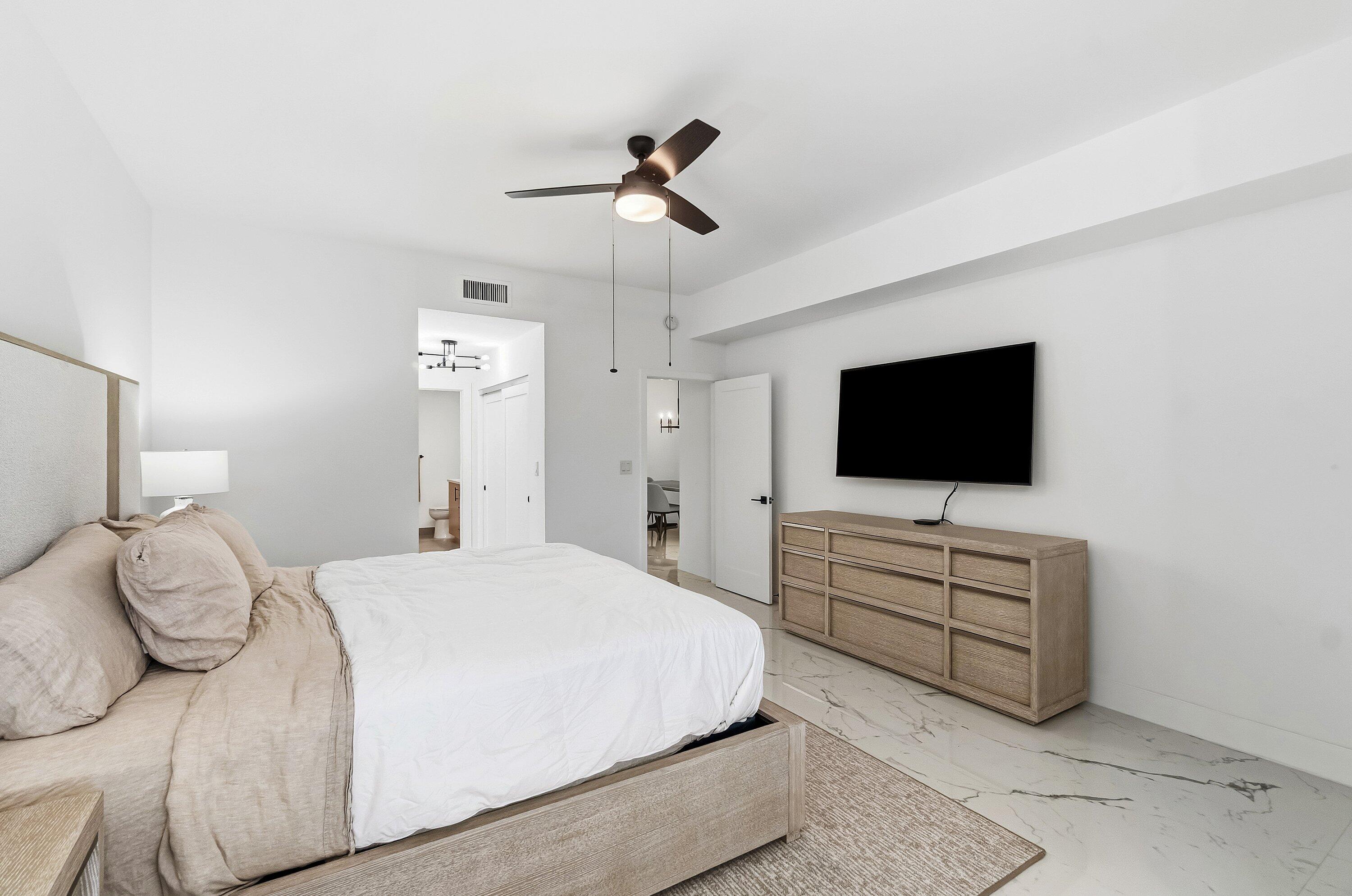 5082 Lake Catalina Drive, Unit A Boca Raton, FL 33496 - Photo 13 of 35 a bedroom with a bed and a flat screen tv
