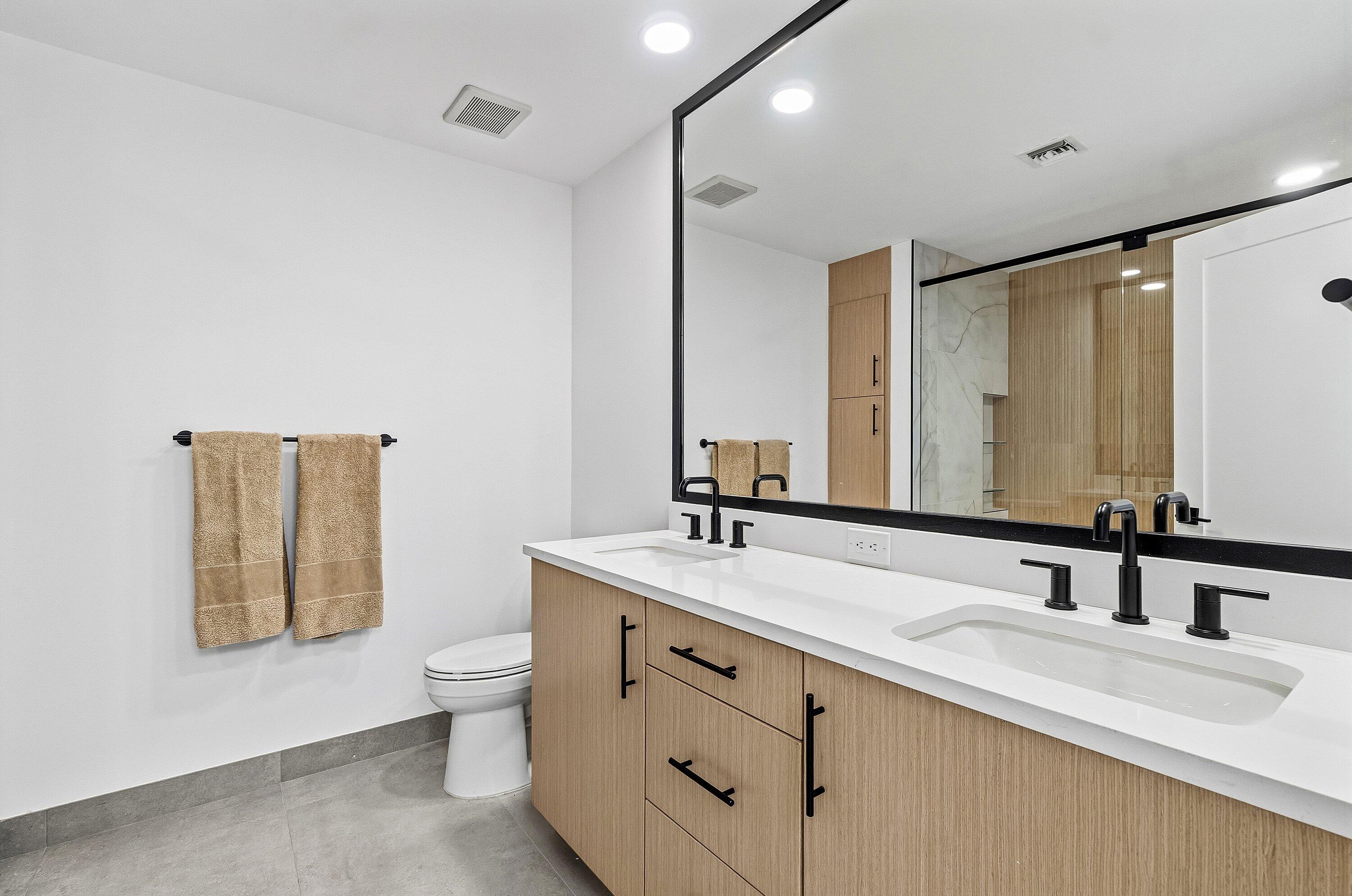 5082 Lake Catalina Drive, Unit A Boca Raton, FL 33496 - Photo 15 of 35 a bathroom with a double vanity sink toilet and mirror