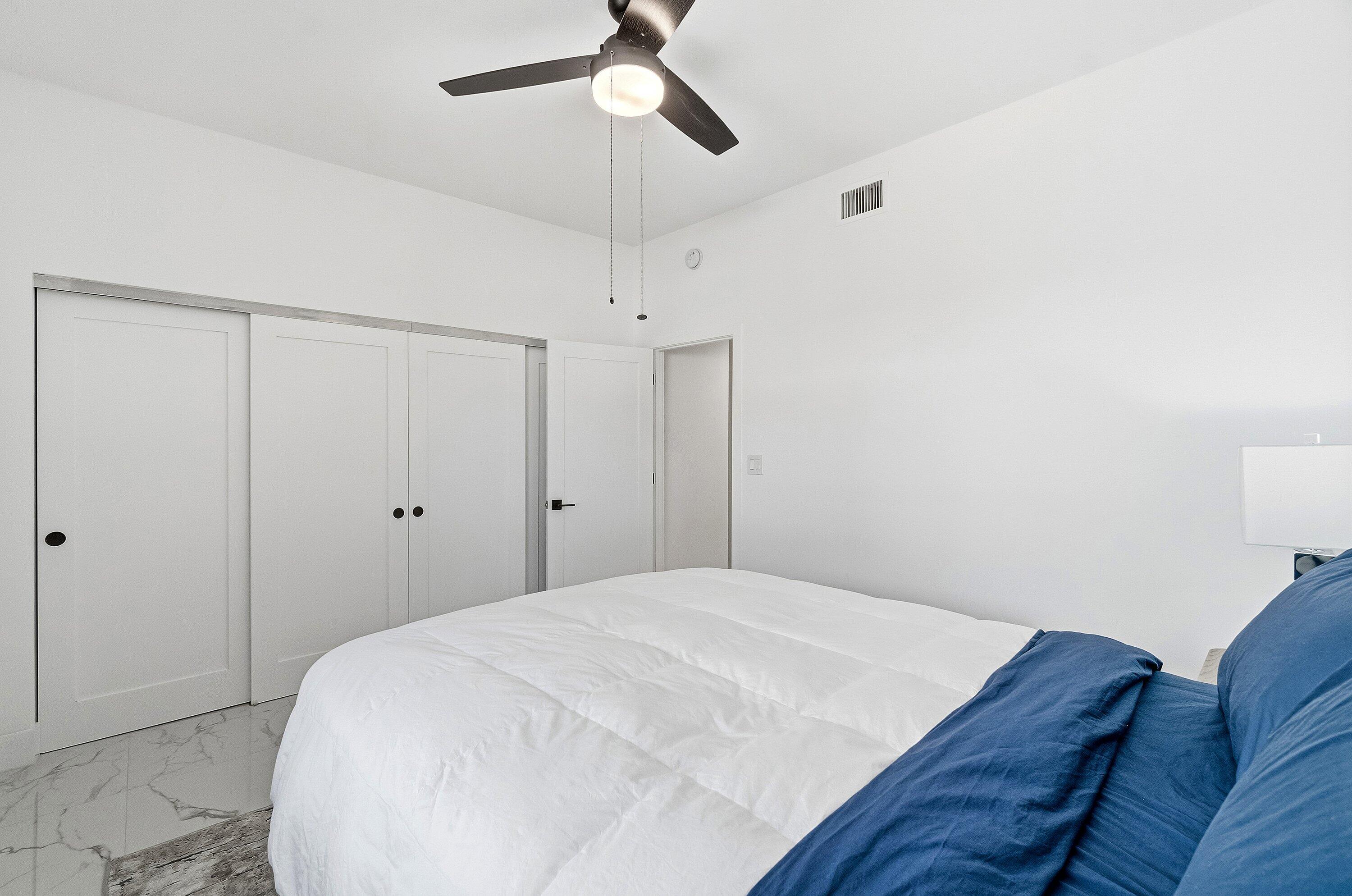 5082 Lake Catalina Drive, Unit A Boca Raton, FL 33496 - Photo 19 of 35 a bedroom with a bed and a chandelier