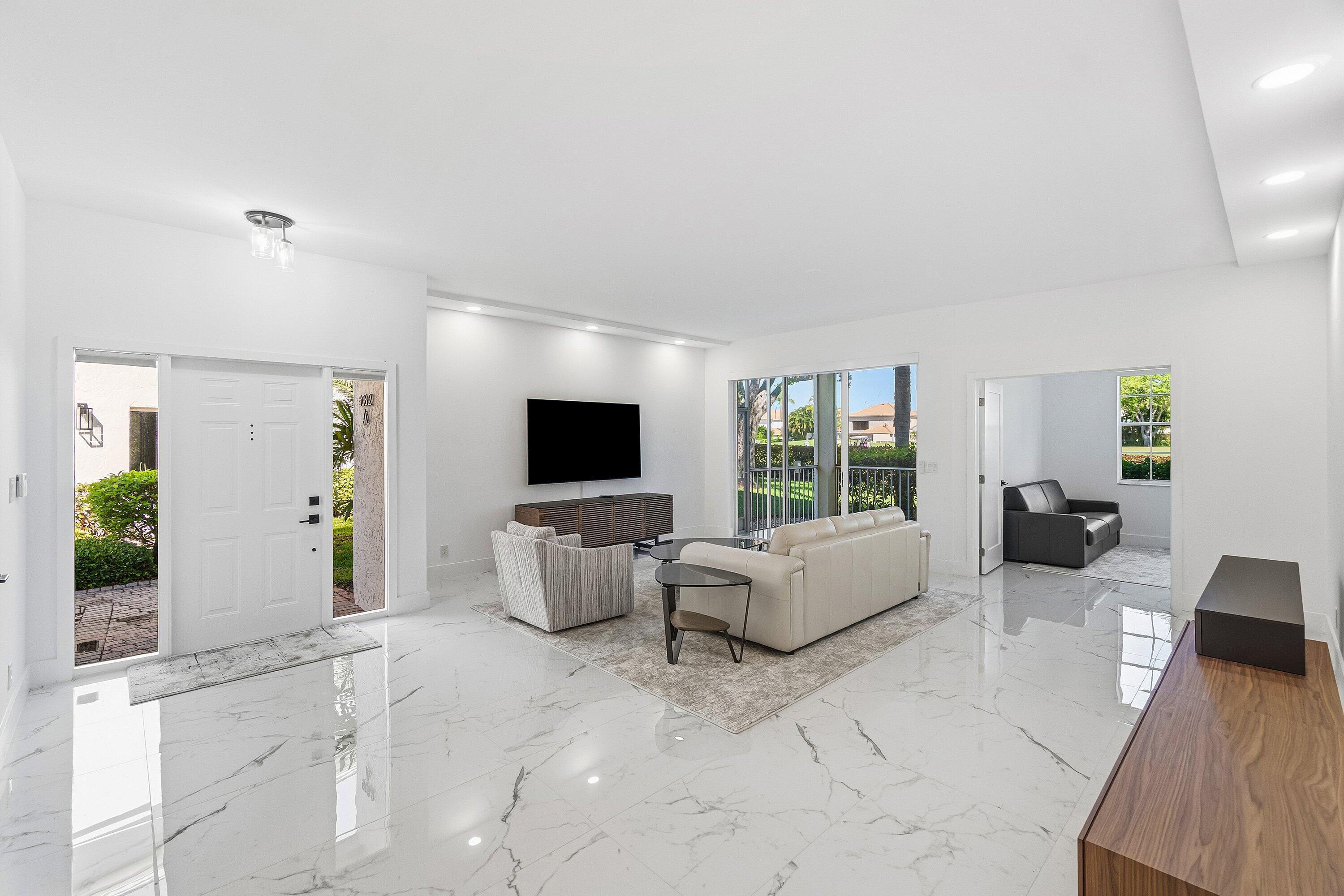 5082 Lake Catalina Drive, Unit A Boca Raton, FL 33496 - Photo 2 of 35 a living room with furniture and a flat screen tv
