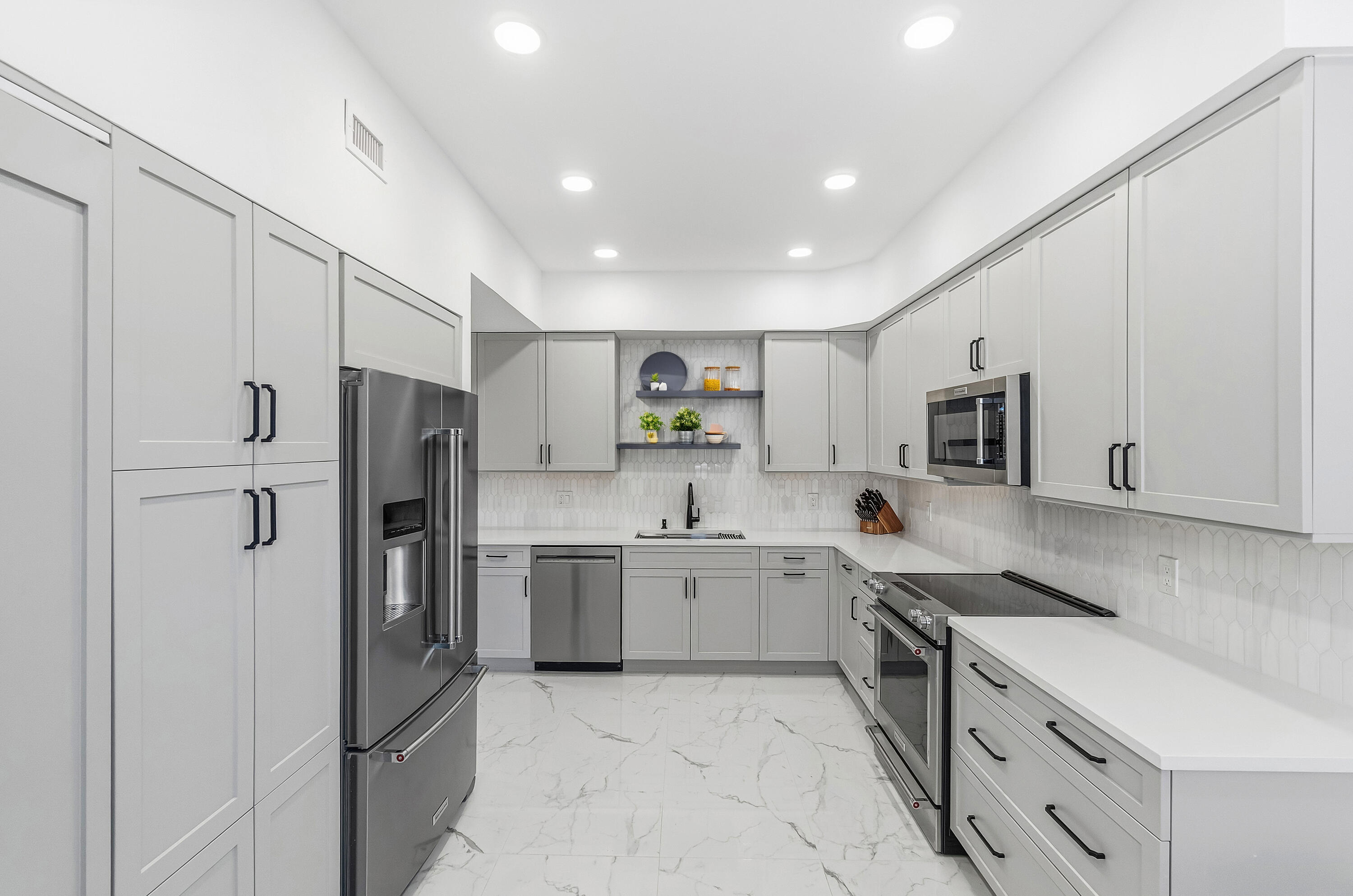 5082 Lake Catalina Drive, Unit A Boca Raton, FL 33496 - Photo 6 of 35 a kitchen with stainless steel appliances granite countertop a refrigerator and a stove top oven