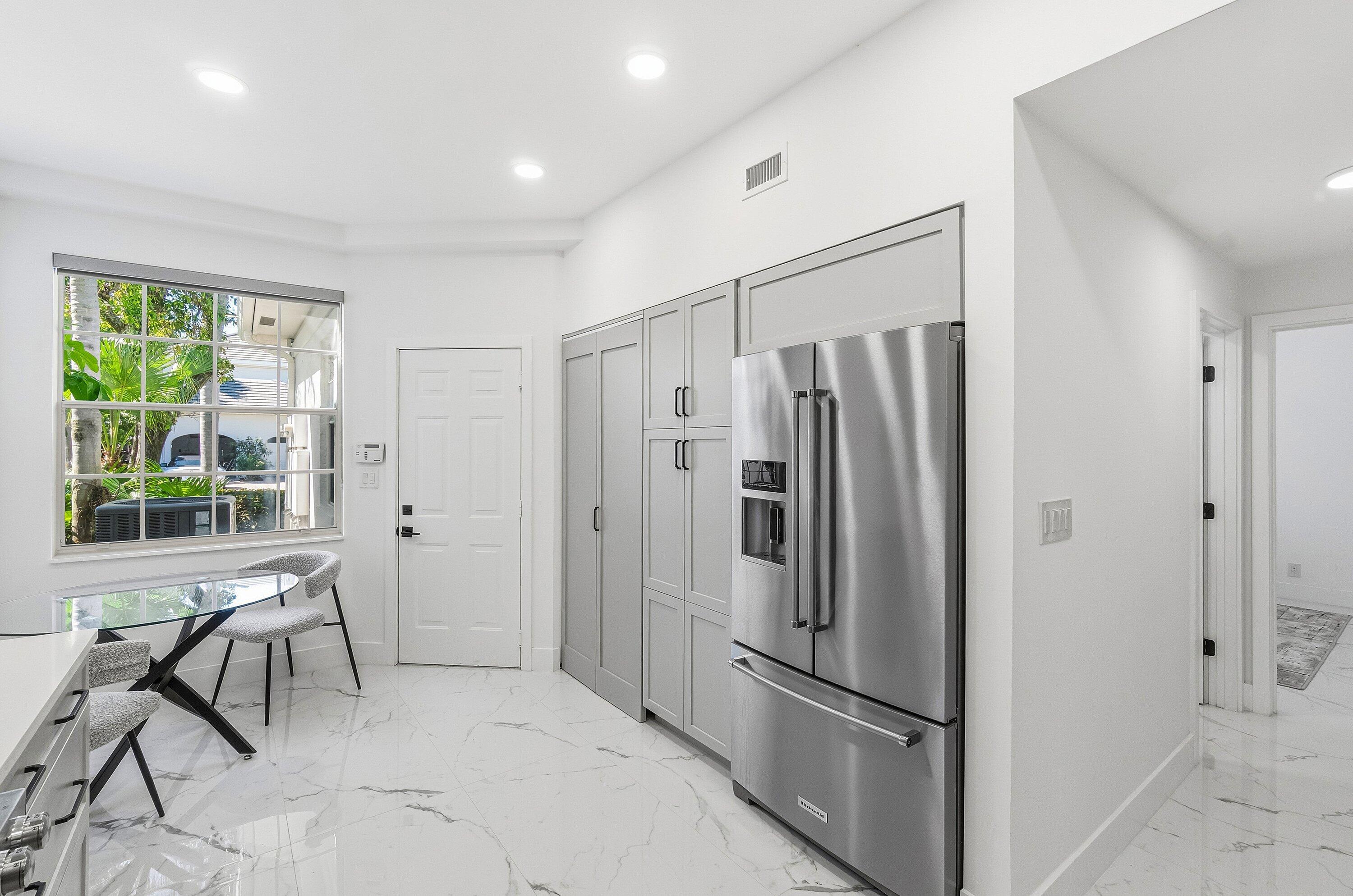 5082 Lake Catalina Drive, Unit A Boca Raton, FL 33496 - Photo 9 of 35 a metallic refrigerator freezer sitting in a kitchen