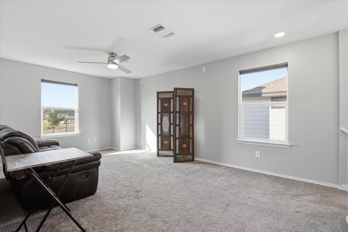 104 Rooster Way Jarrell, TX 76537 - Photo 15 of 33 A spacious upstairs loft boasts plush carpeting and abundant natural light from large windows.