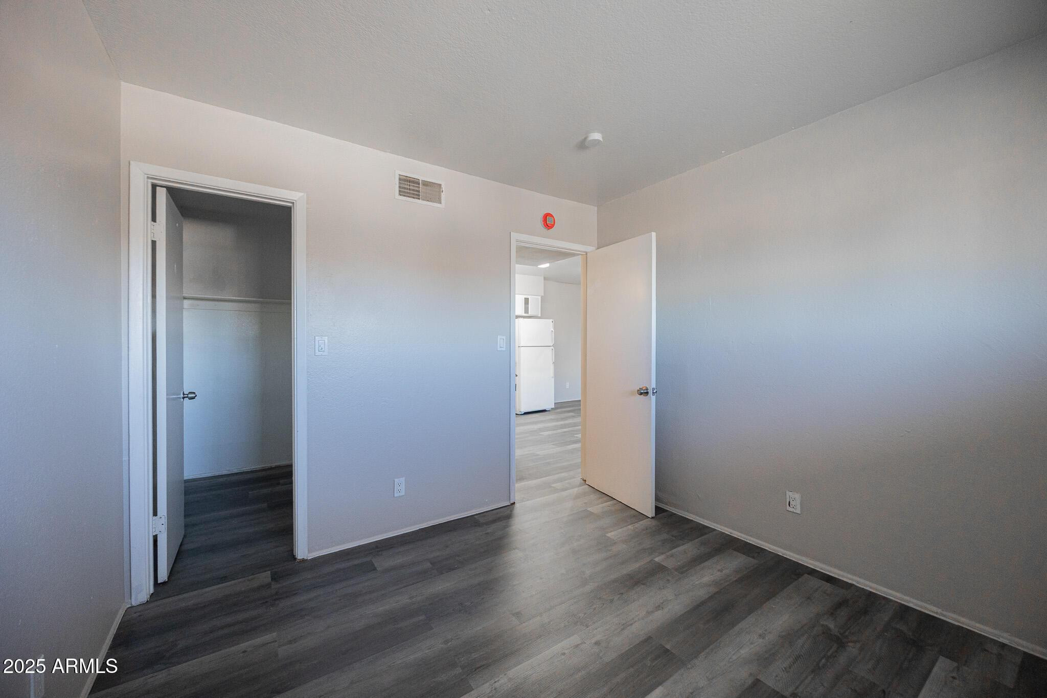 1703 West Mountain View Road, Unit 14 Phoenix, AZ 85021 - Photo 11 of 14 a view of an empty room with wooden floor and closet