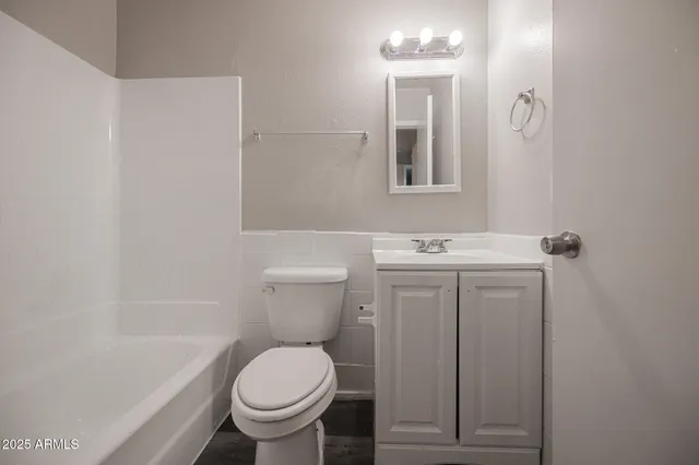 a white toilet sitting next to a bathroom sink