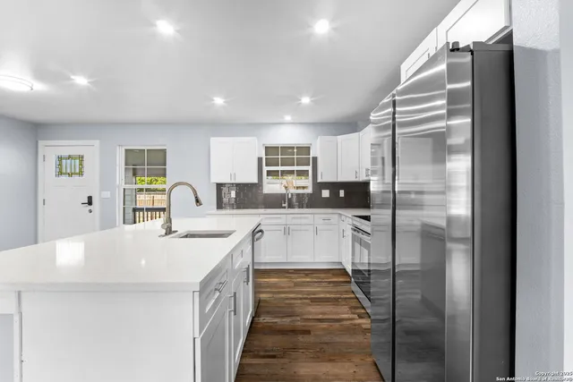 a kitchen with stainless steel appliances granite countertop a refrigerator and a sink