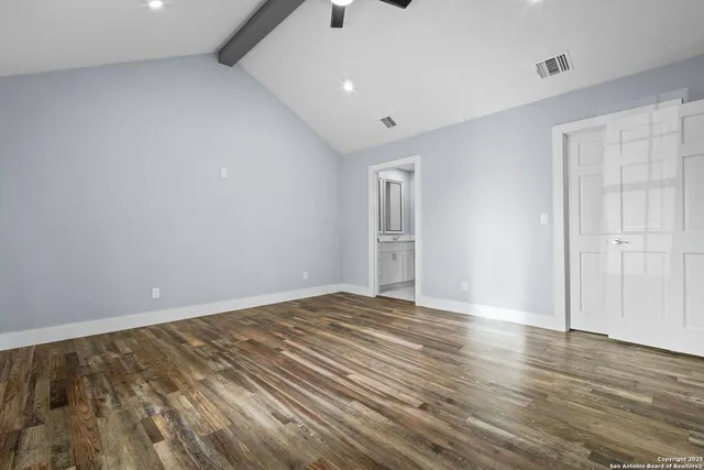 a view of an empty room with wooden floor