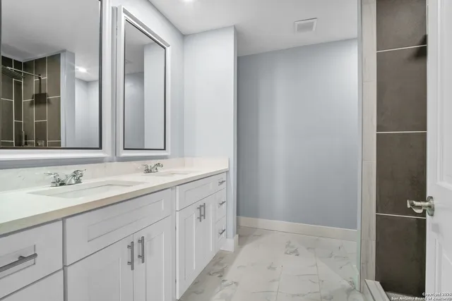 a bathroom with a double vanity sink and mirror