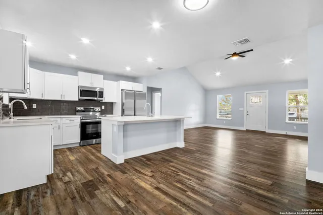 a kitchen with a refrigerator and white cabinets