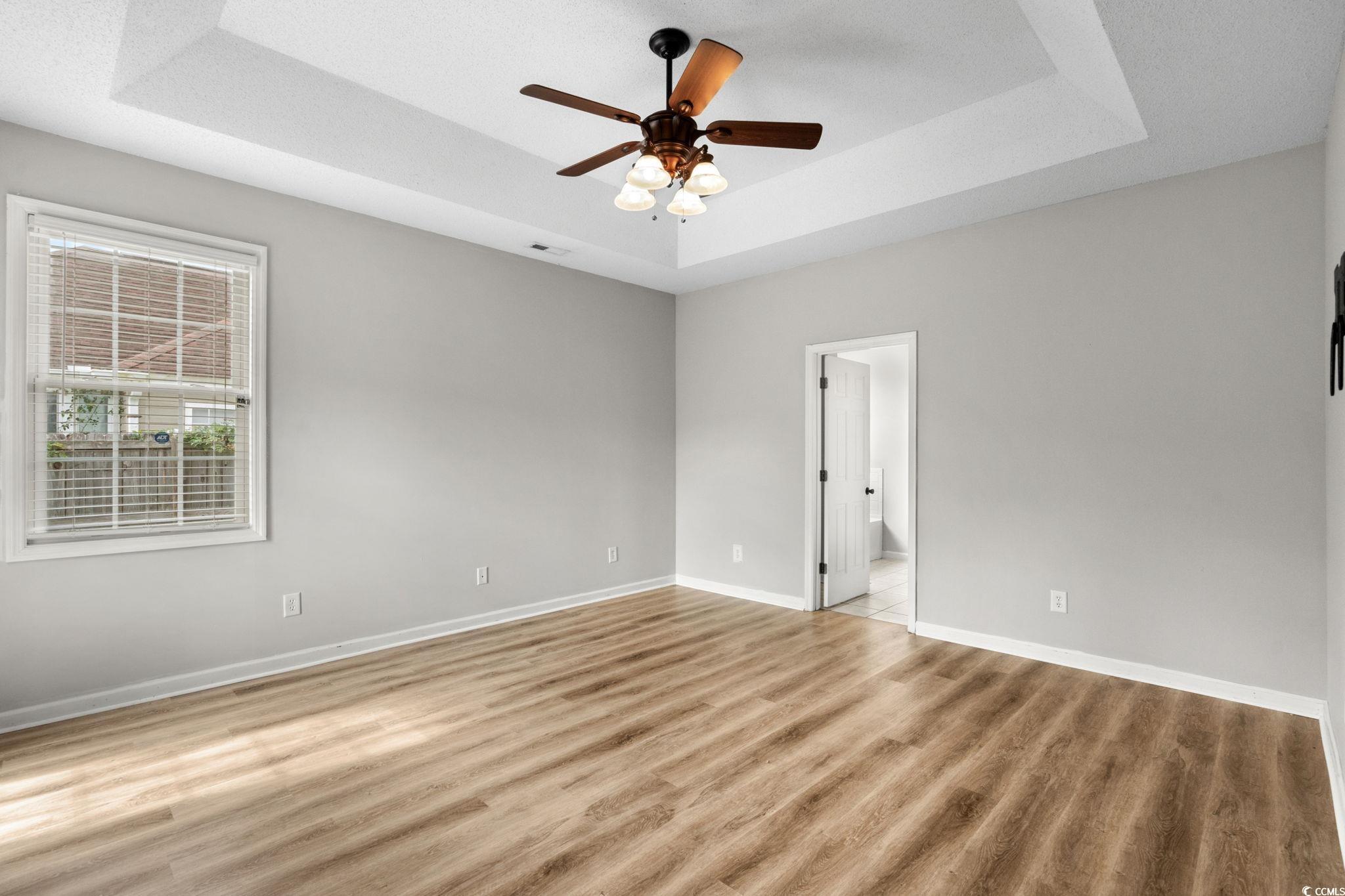 2723 Canvasback Trail Myrtle Beach, SC 29588 - Photo 20 of 40 Spare room featuring a tray ceiling, light wood-style flooring, and ceiling fan