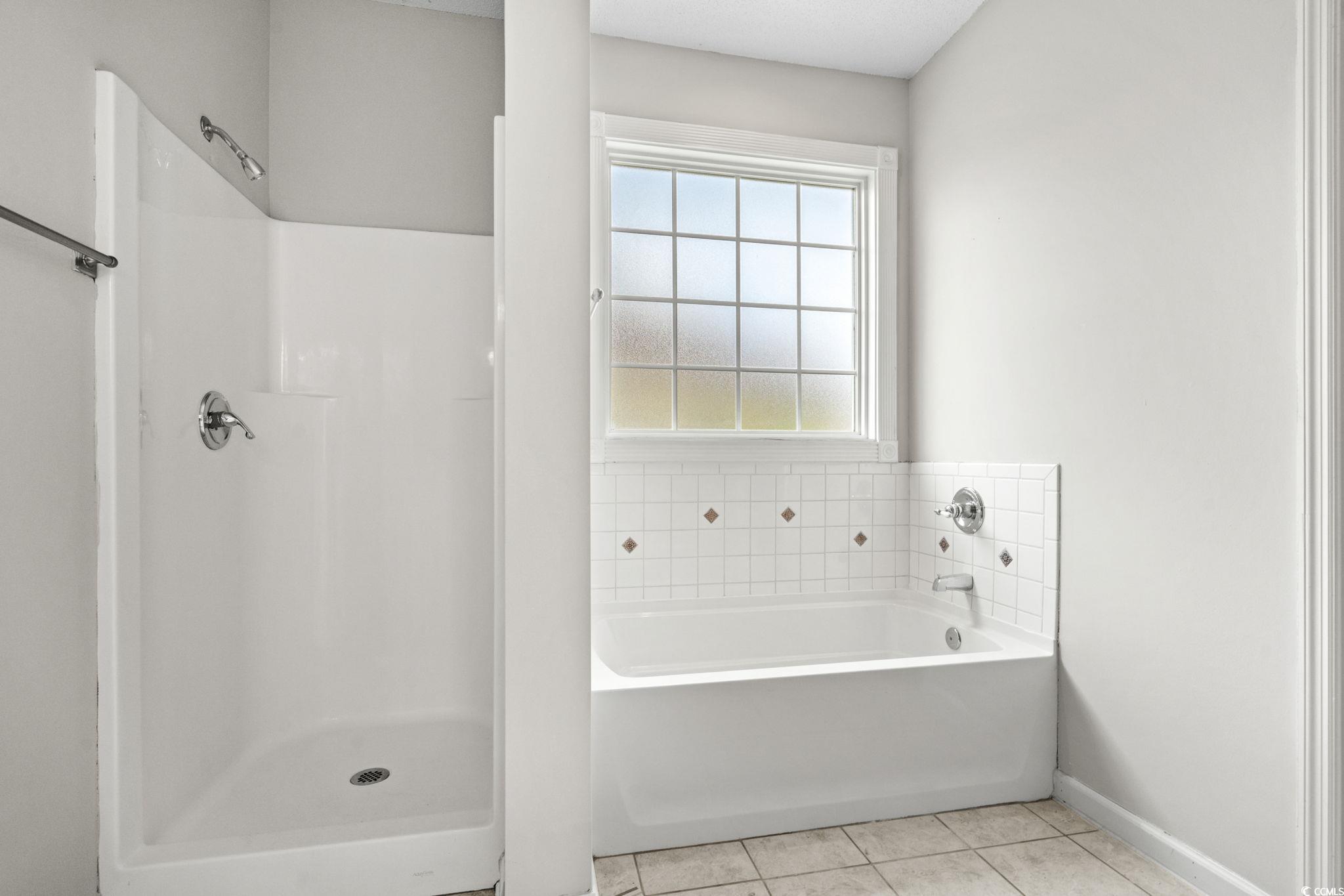 2723 Canvasback Trail Myrtle Beach, SC 29588 - Photo 22 of 40 Bathroom featuring light tile patterned floors, a bath, and a shower stall