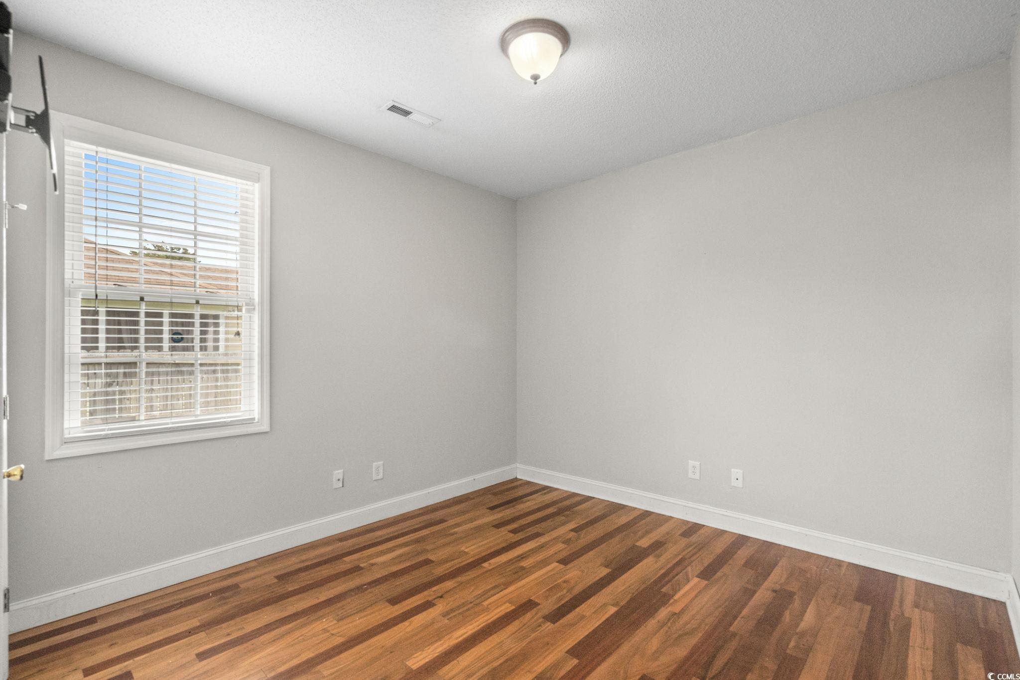 2723 Canvasback Trail Myrtle Beach, SC 29588 - Photo 24 of 40 Spare room featuring dark wood-style flooring and a textured ceiling