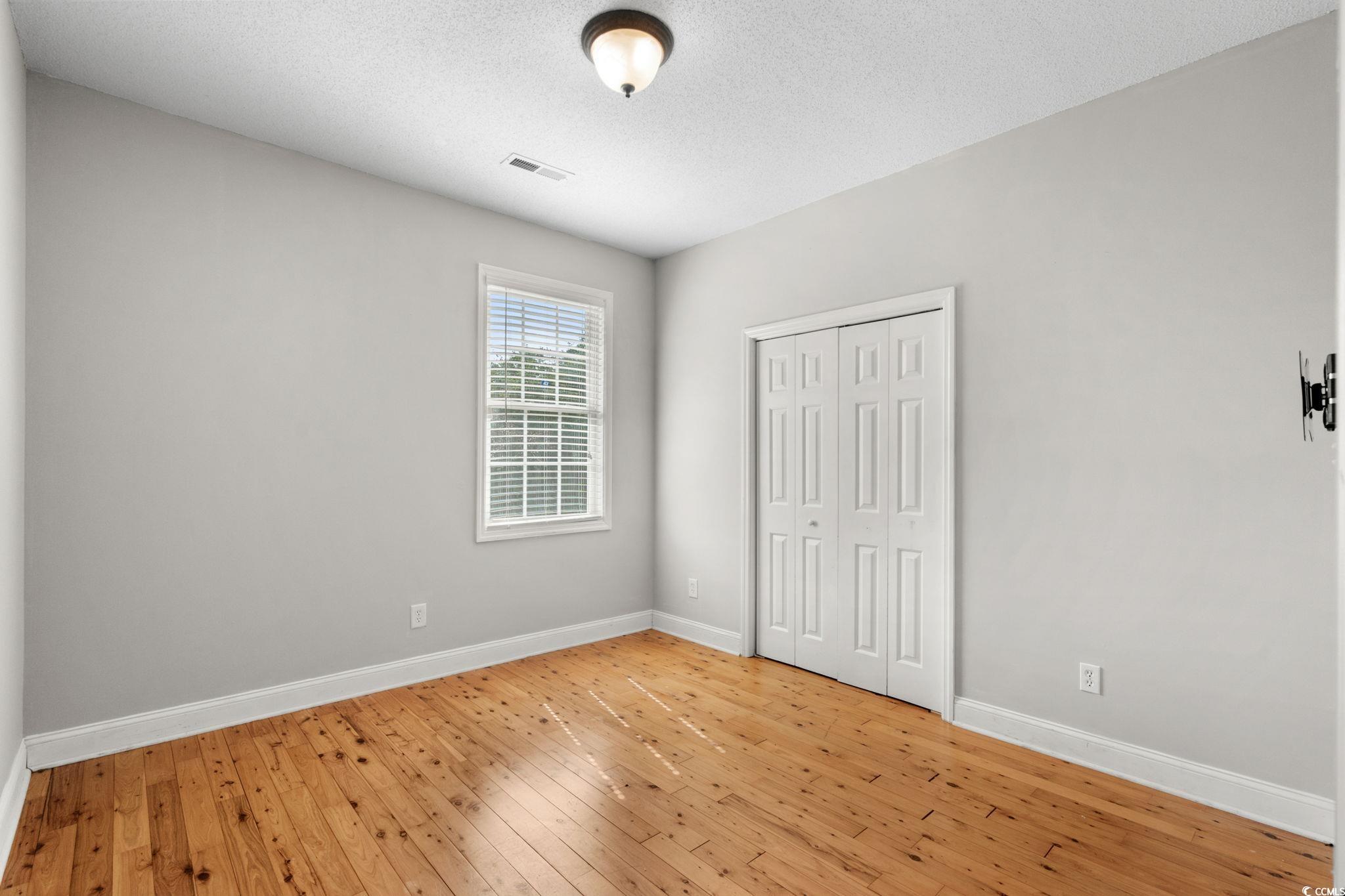 2723 Canvasback Trail Myrtle Beach, SC 29588 - Photo 25 of 40 Unfurnished bedroom with hardwood / wood-style floors, a textured ceiling, and a closet