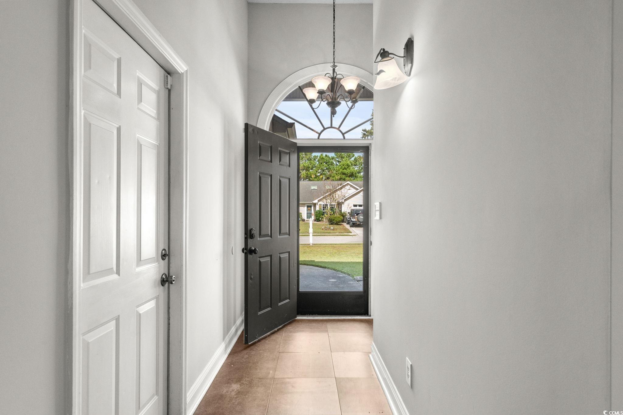 2723 Canvasback Trail Myrtle Beach, SC 29588 - Photo 4 of 40 Foyer entrance with a chandelier and tile patterned floors
