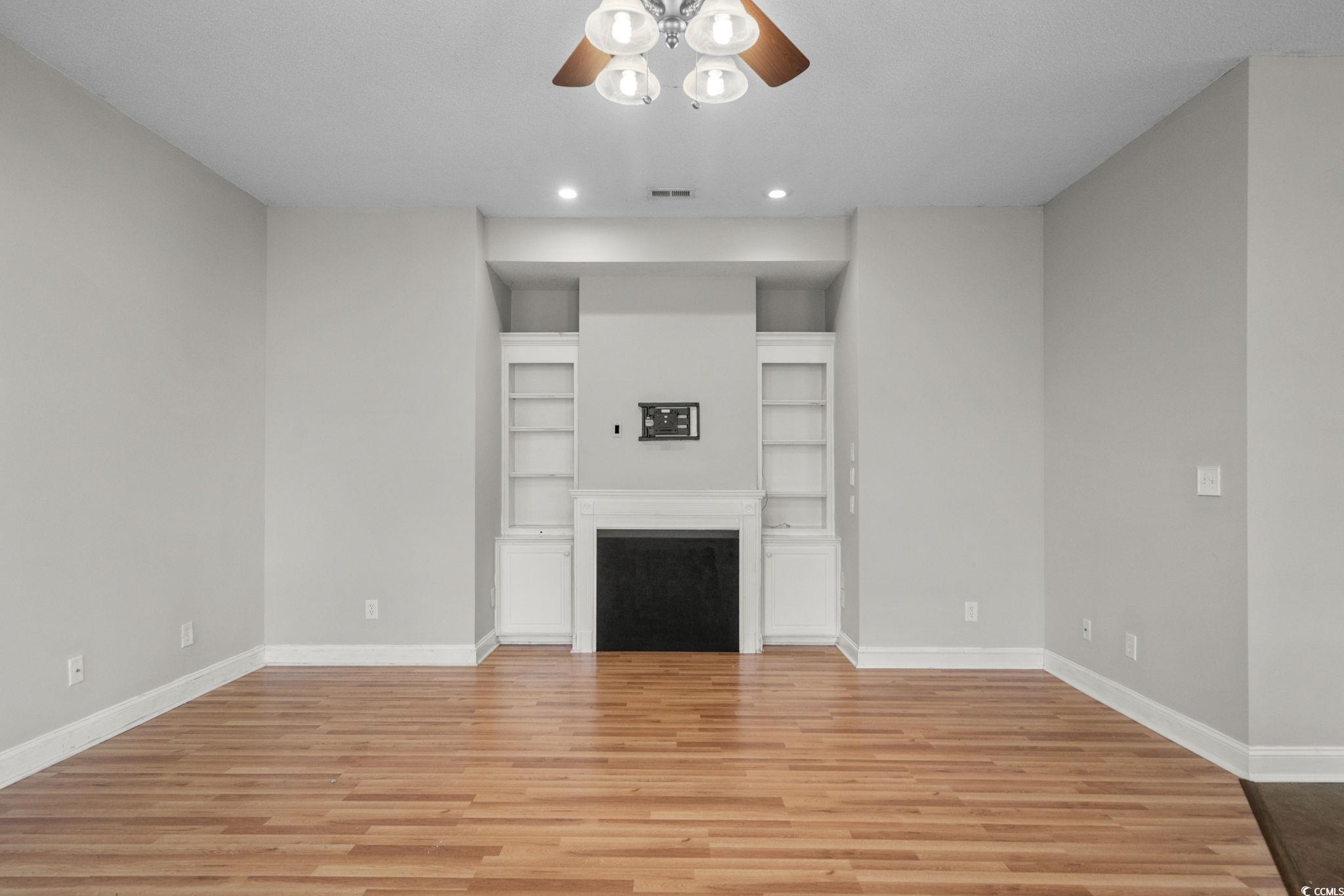 2723 Canvasback Trail Myrtle Beach, SC 29588 - Photo 7 of 40 Unfurnished living room with light wood-style flooring, recessed lighting, ceiling fan, built in features, and a fireplace