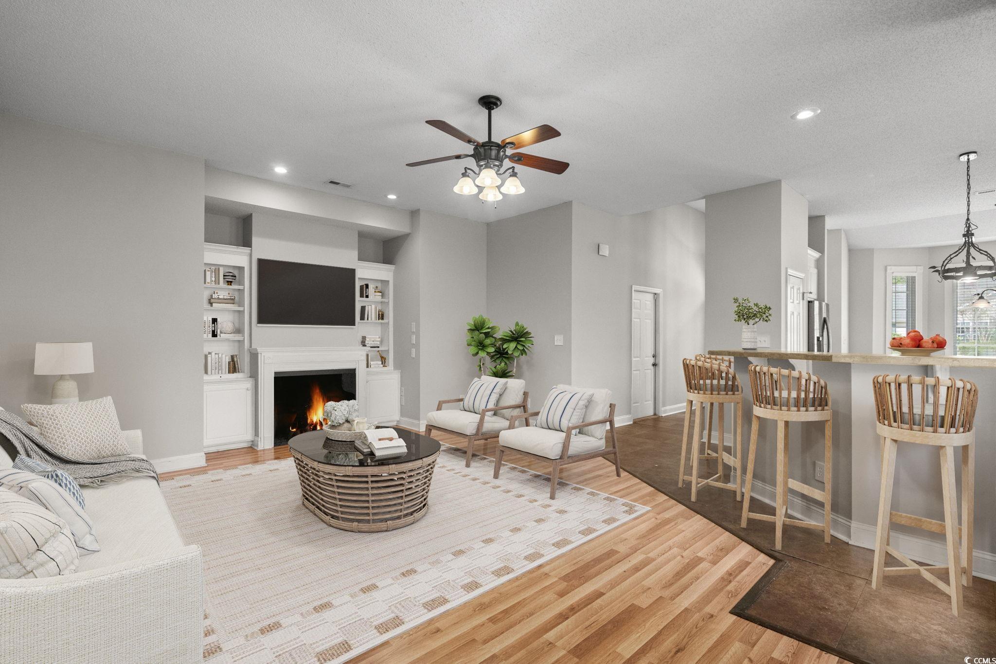 2723 Canvasback Trail Myrtle Beach, SC 29588 - Photo 8 of 40 Living room with wood finished floors, a warm lit fireplace, built in shelves, recessed lighting, and ceiling fan