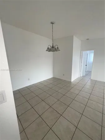 a view of a room with a chandelier fan and windows