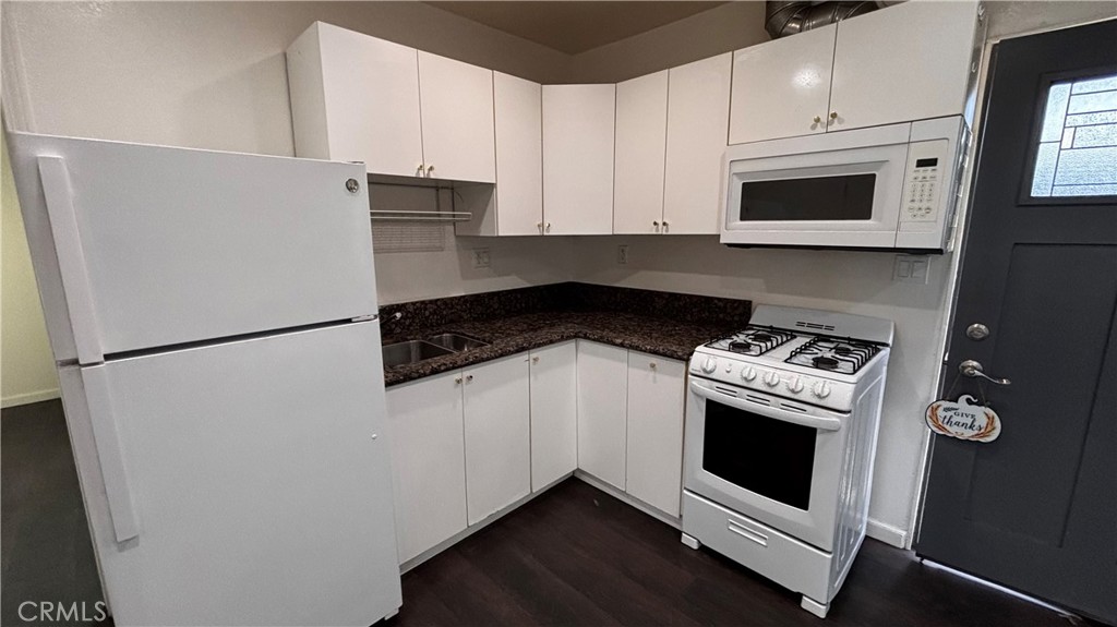 7922 Lindley Avenue Reseda, CA 91335 - Photo 5 of 11 a kitchen with stainless steel appliances a refrigerator stove and microwave