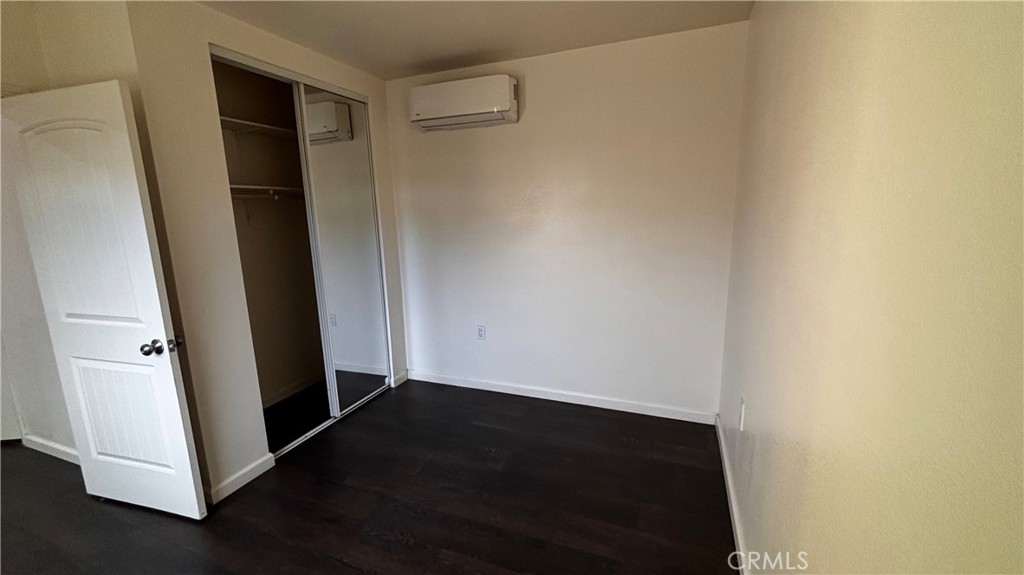 7922 Lindley Avenue Reseda, CA 91335 - Photo 8 of 11 an empty room with wooden floor and a window