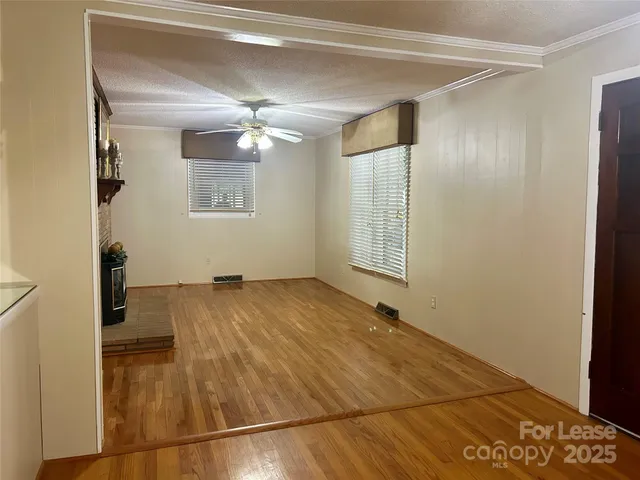 a view of empty room with wooden floor
