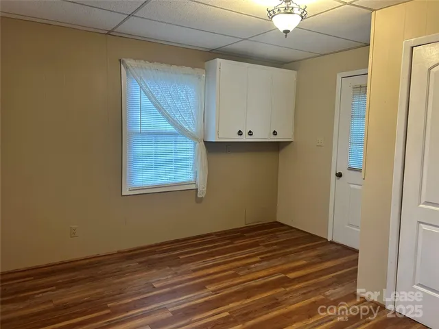 an empty room with wooden floor and cabinet