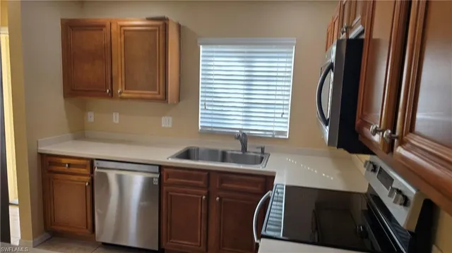 a kitchen with granite countertop a sink and a refrigerator